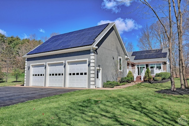 view of property exterior featuring a lawn, solar panels, a porch, and a garage