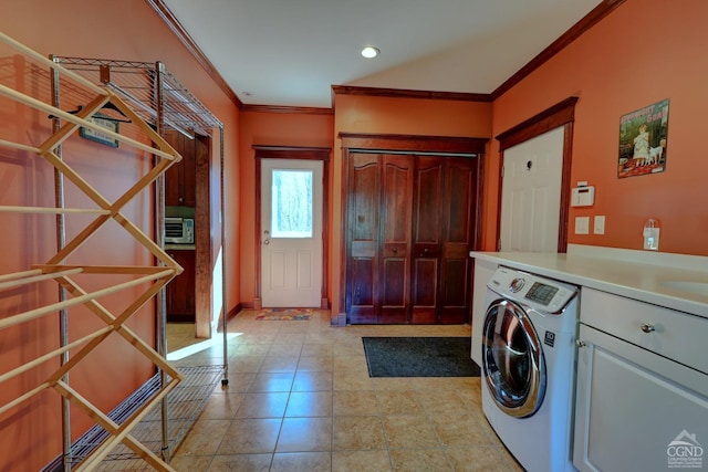 washroom with crown molding, cabinets, and washer / dryer