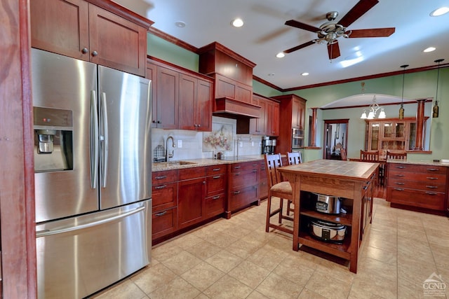 kitchen with sink, decorative light fixtures, decorative backsplash, ceiling fan with notable chandelier, and appliances with stainless steel finishes