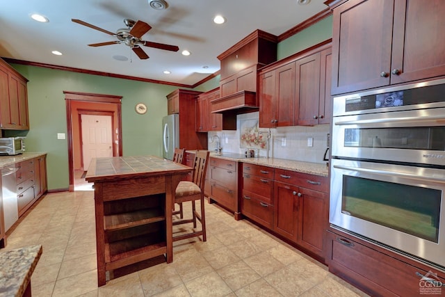 kitchen with tasteful backsplash, ornamental molding, stainless steel appliances, ceiling fan, and light tile patterned flooring