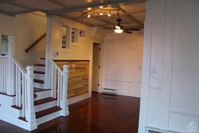 stairway with ceiling fan, wooden walls, wood-type flooring, and a baseboard heating unit