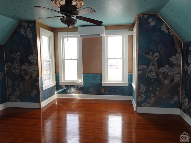 interior space with wood-type flooring, an AC wall unit, ceiling fan, and lofted ceiling