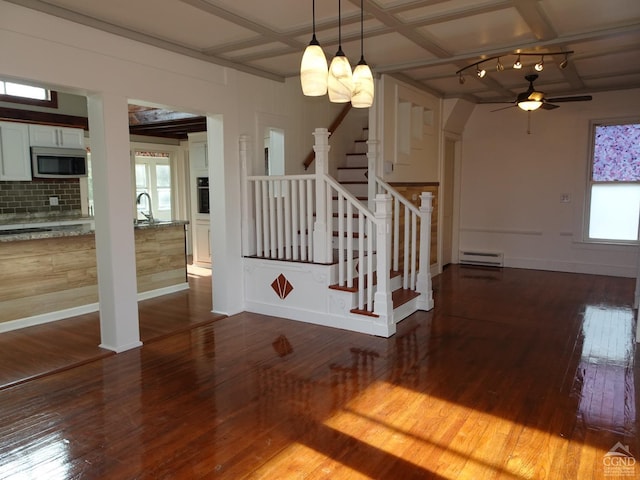 stairs with coffered ceiling, hardwood / wood-style flooring, ceiling fan, a baseboard radiator, and beamed ceiling