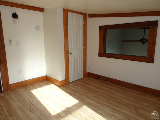 empty room featuring ceiling fan, light wood-type flooring, and vaulted ceiling