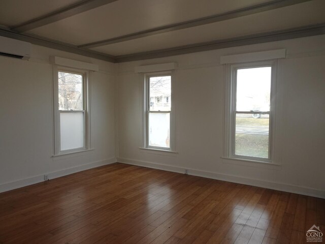 unfurnished room featuring an AC wall unit and wood-type flooring