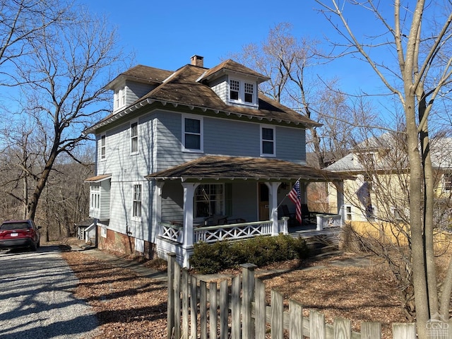 traditional style home featuring covered porch and a chimney