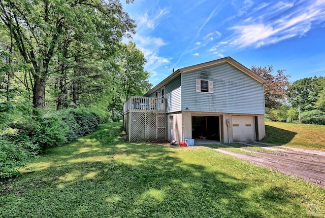 view of property exterior with a garage, driveway, a yard, and a wooden deck