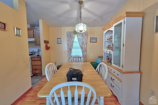 dining area with light wood-style flooring and baseboards