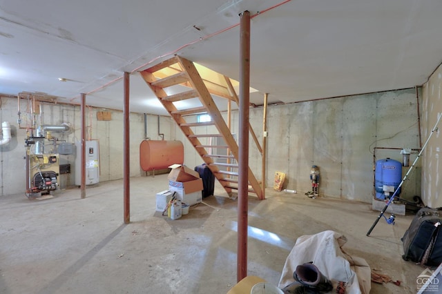 unfinished basement with heating fuel, a heating unit, and electric water heater