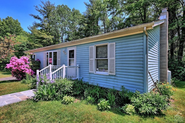 view of front of house with a chimney and a front lawn