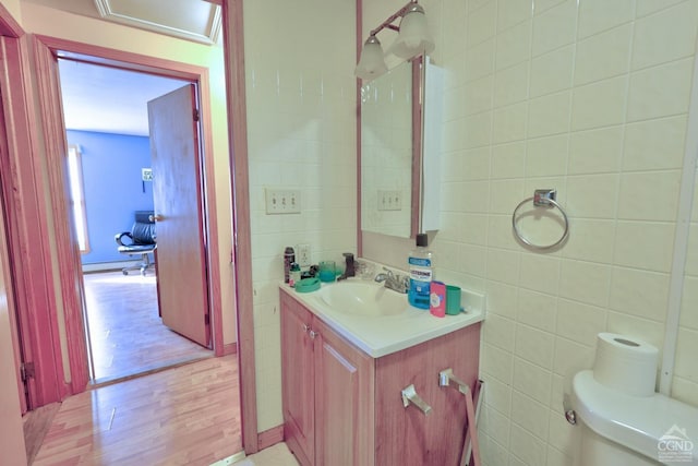 bathroom featuring a baseboard radiator, vanity, tile walls, and wood finished floors