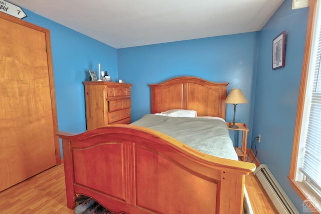 bedroom featuring a baseboard radiator and light wood finished floors