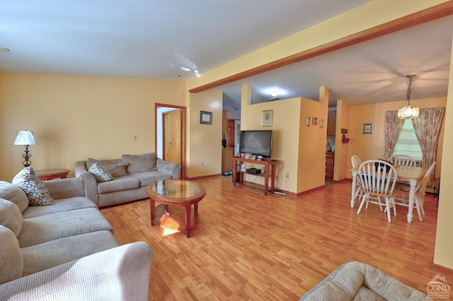 living room with vaulted ceiling, light wood-style flooring, and baseboards