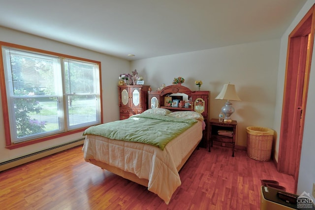 bedroom featuring baseboard heating and wood finished floors