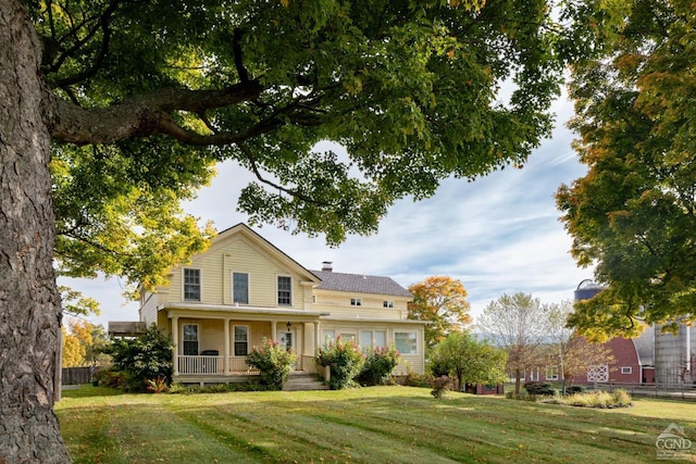 view of front of house with covered porch and a front lawn