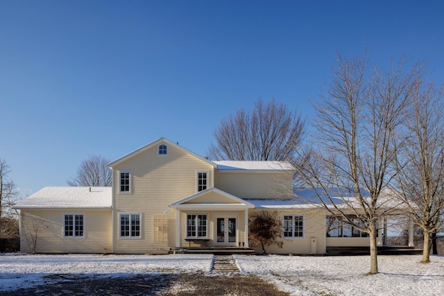 snow covered property with french doors