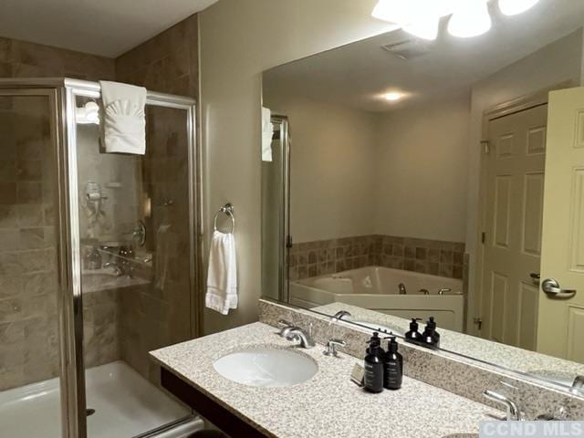 bathroom featuring shower with separate bathtub and vanity