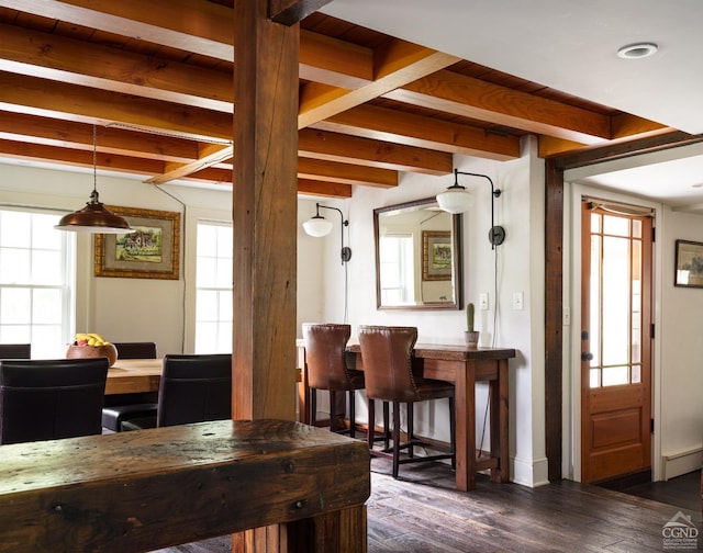 dining space featuring beamed ceiling, dark wood-type flooring, and a baseboard radiator