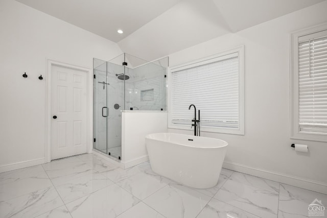 bathroom featuring marble finish floor, a stall shower, a freestanding bath, and baseboards