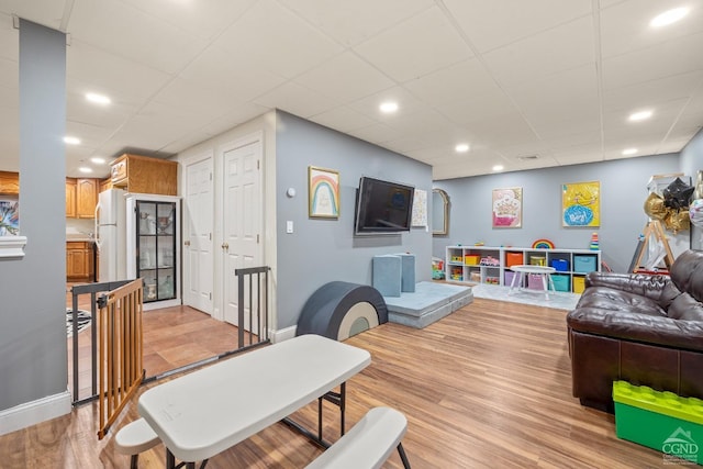 playroom with recessed lighting, baseboards, light wood-type flooring, and a paneled ceiling