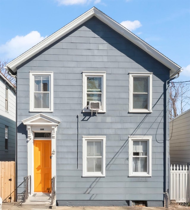 view of front of home with cooling unit and fence