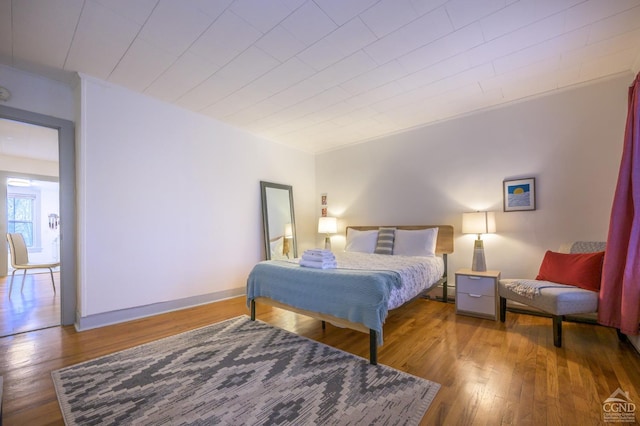 bedroom featuring baseboards and hardwood / wood-style floors