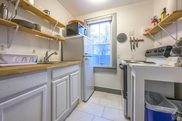 clothes washing area with baseboards and a sink