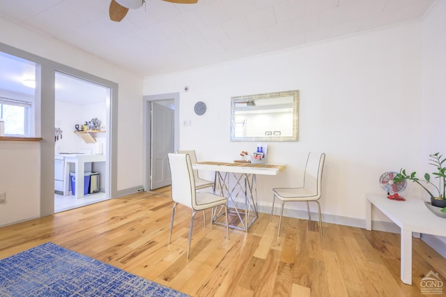 dining space featuring baseboards, wood-type flooring, and ceiling fan