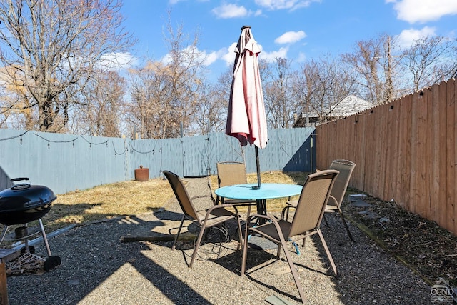 view of patio featuring grilling area, a fenced backyard, and outdoor dining space