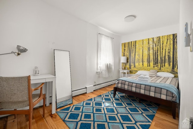 bedroom featuring a baseboard heating unit and wood finished floors