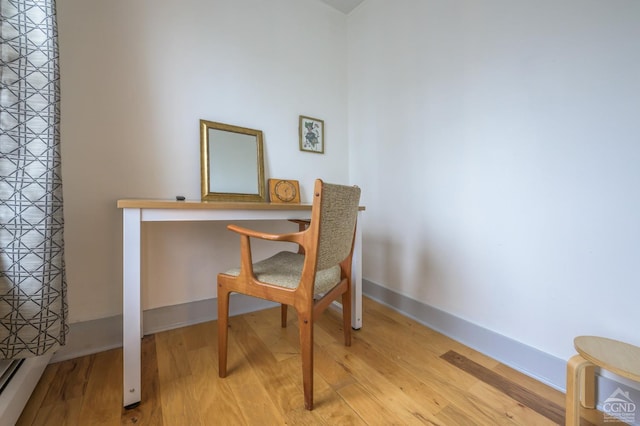 office area with baseboards and wood finished floors