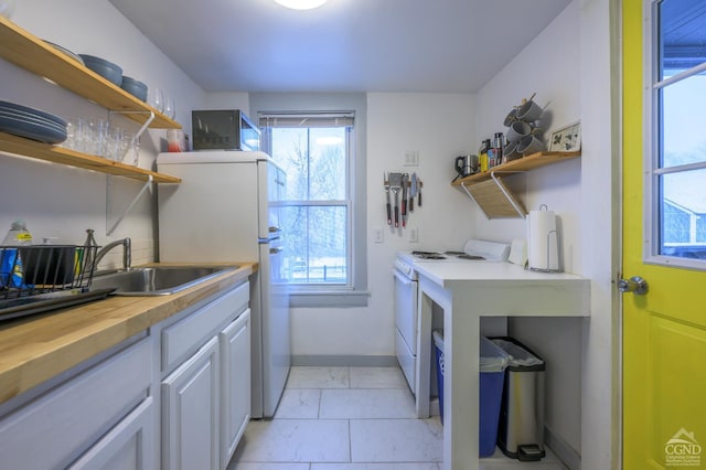 laundry area featuring baseboards and a sink