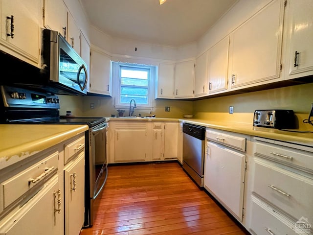 kitchen featuring white cabinets, hardwood / wood-style floors, and stainless steel appliances