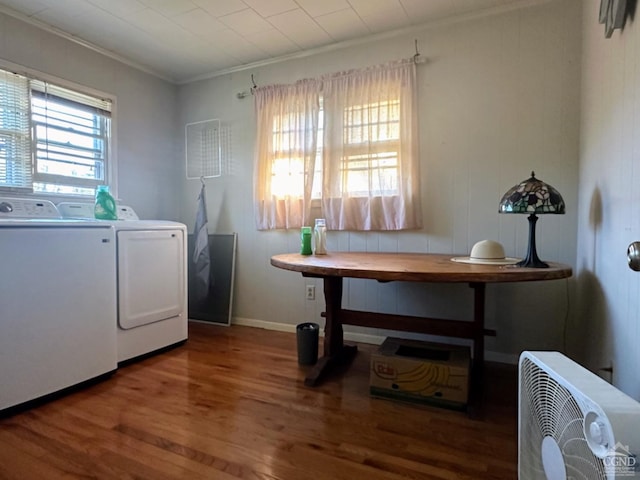 clothes washing area featuring hardwood / wood-style floors, washing machine and dryer, and crown molding