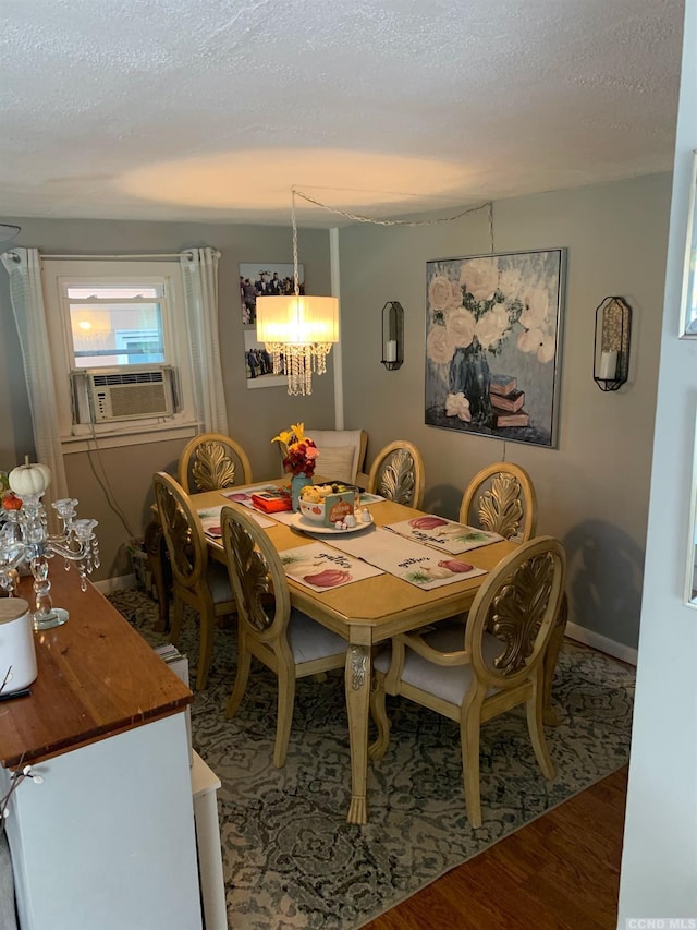 dining area with a chandelier, cooling unit, wood-type flooring, and a textured ceiling