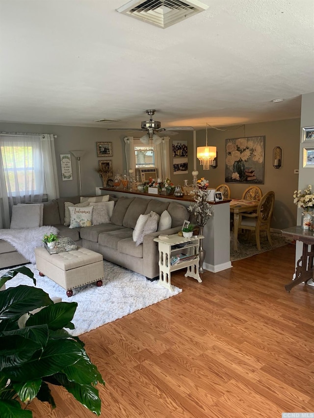 living room with wood-type flooring and ceiling fan