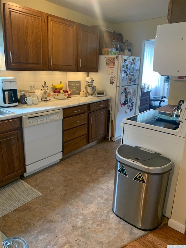 kitchen featuring backsplash and white appliances