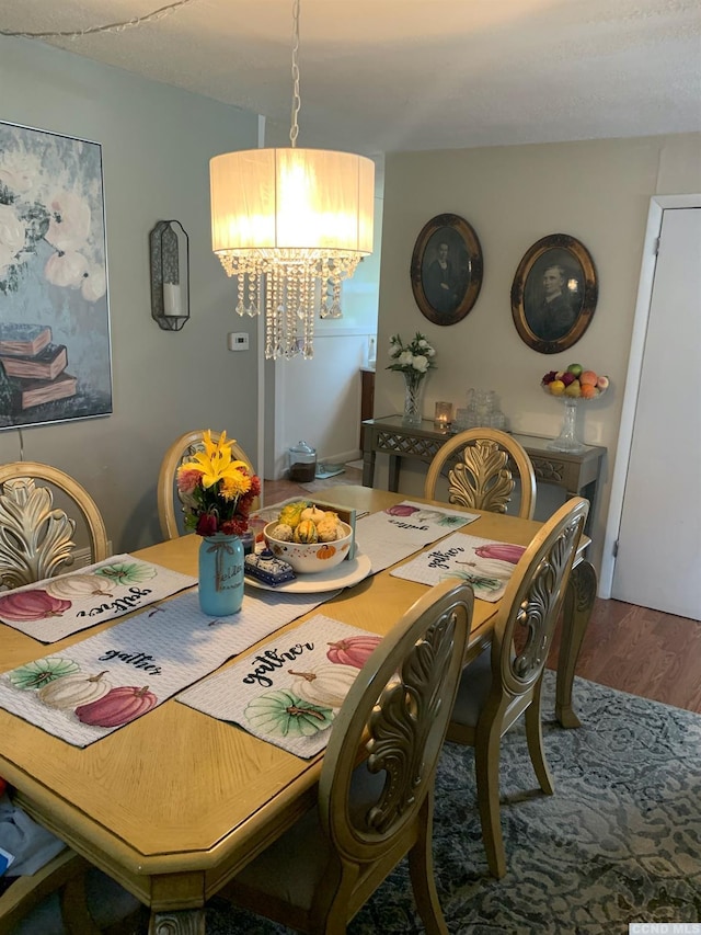 dining room featuring wood-type flooring and an inviting chandelier