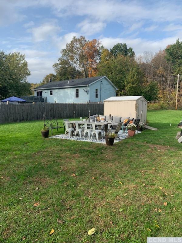 view of yard featuring a patio and a shed