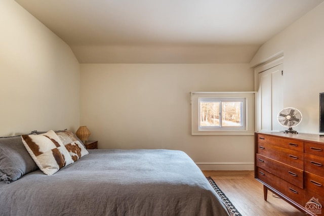 bedroom with lofted ceiling and light hardwood / wood-style flooring