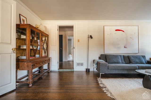 living room with crown molding and dark wood-type flooring