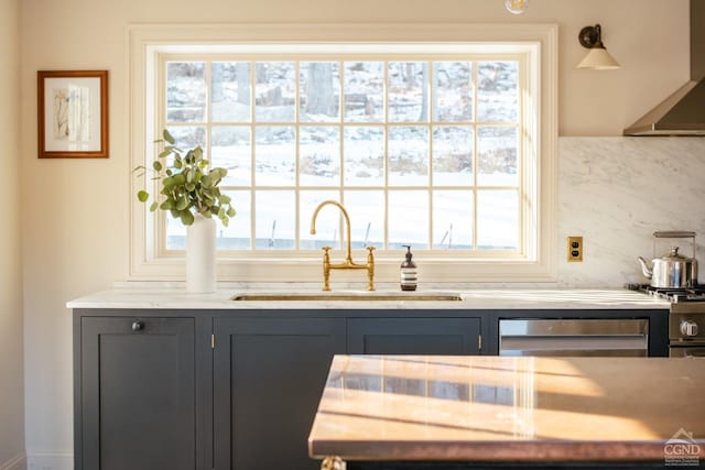 bar featuring range hood, sink, dishwasher, and a wealth of natural light