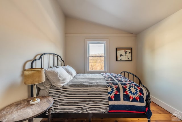 bedroom with lofted ceiling and wood-type flooring