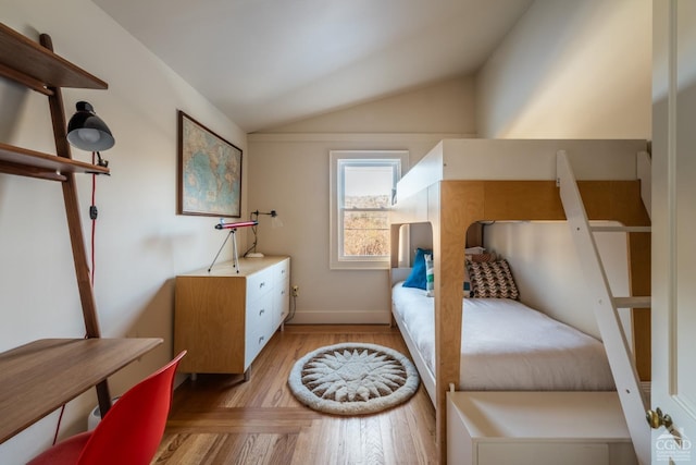 bedroom with lofted ceiling and light wood-type flooring