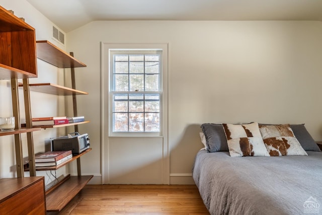 bedroom featuring lofted ceiling and light hardwood / wood-style floors