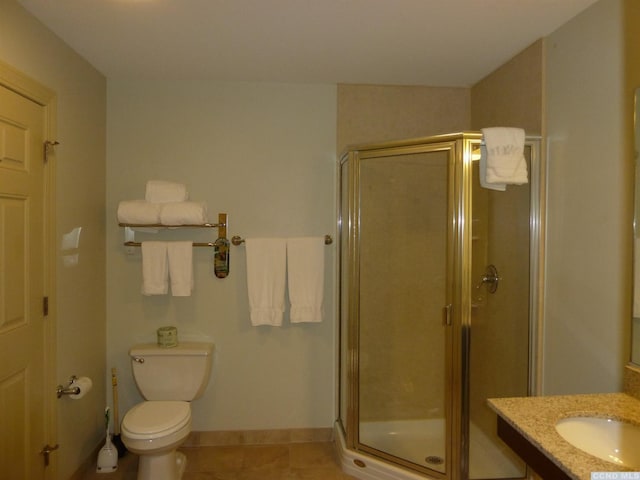 bathroom featuring tile patterned flooring, vanity, toilet, and a shower with shower door