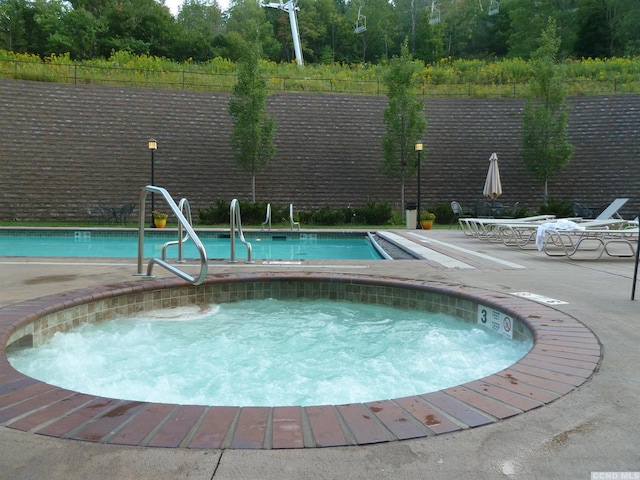 view of pool with a hot tub