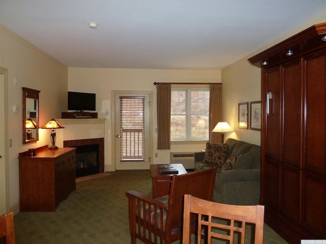 carpeted living room featuring an AC wall unit and a fireplace