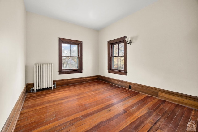 spare room featuring hardwood / wood-style flooring and radiator