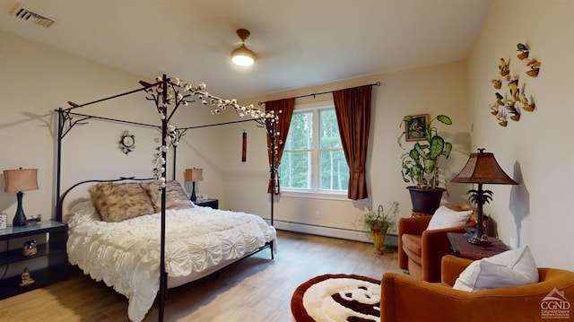 bedroom with hardwood / wood-style floors, ceiling fan, and a baseboard radiator